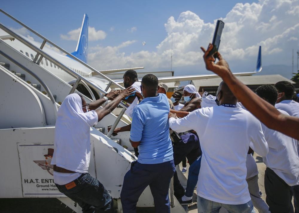 Deported Haitians try to rush back into plane amid anger