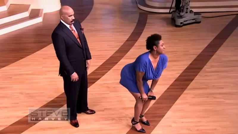 ‘Marjorie … Bout to Get Him’: Watch Steve Harvey ‘Step Back’ as Woman In Blue Dress Attempts to Twerk on Him In Resurfaced Clip